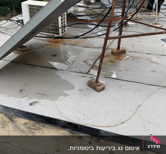 גג עם שלוליות מים, חוטים ומתקן מתכת